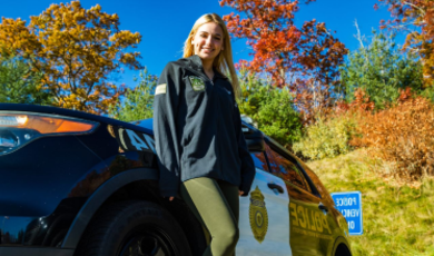 Sarah Carlozzi stands in front of a police cruiser