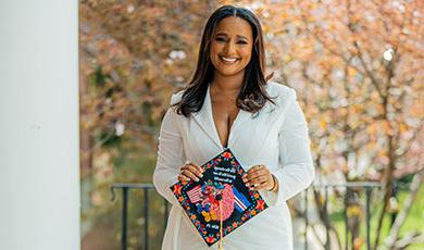 Lina Monteiro holds her colorful graduation cap, which she deocrated with a variety of designs 